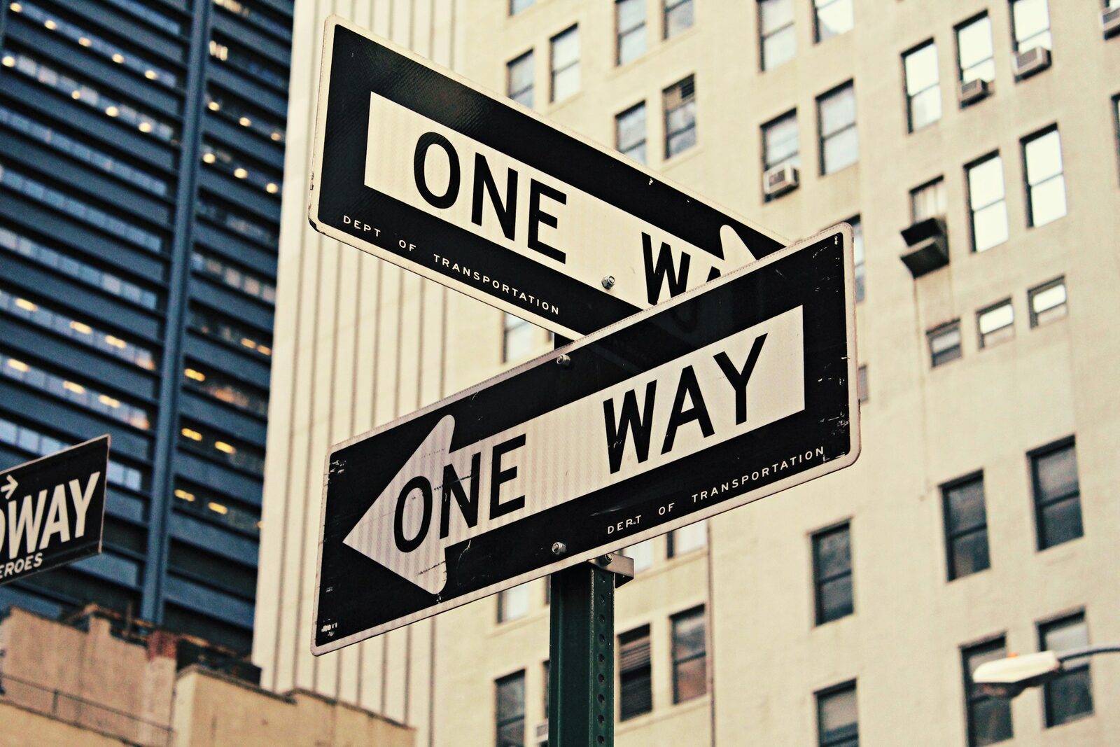 A one-way street sign on an empty road